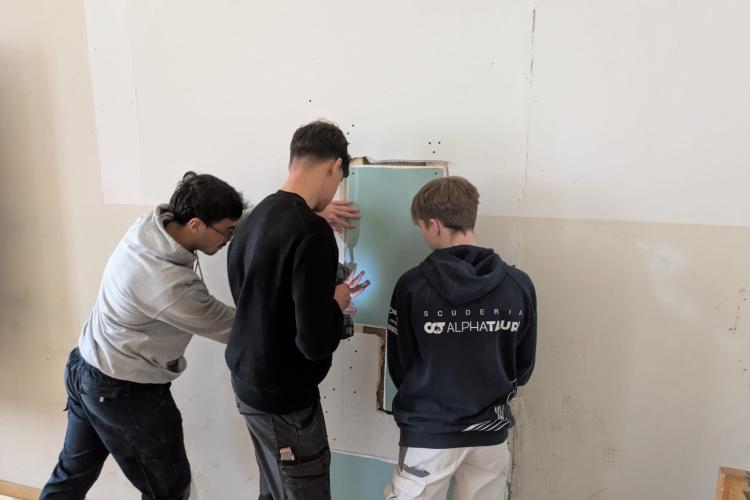 Schüler arbeiten an Wand