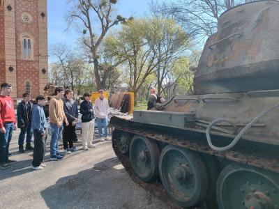 Schülerinnen und Schüler vor einem Kriegsrelikt