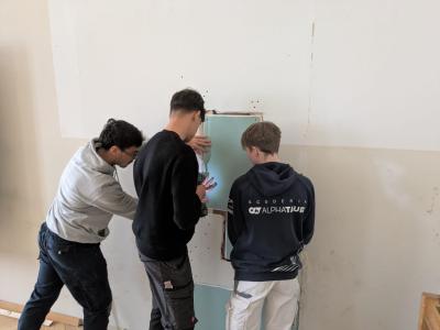 Schüler arbeiten an Wand